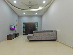 a living room with a couch and a tv at OYO Home 90584 Dz Homestay Bukit Setongkol in Kampong Darat Tanah Puteh