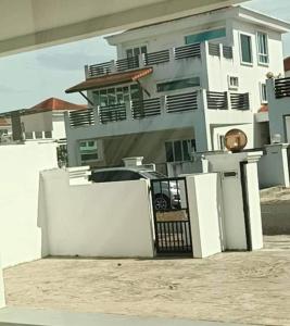 ein großes weißes Haus mit einem weißen Zaun davor in der Unterkunft OYO HOME 90769 Flo Inn Homestay Bsi in Kampong Parit