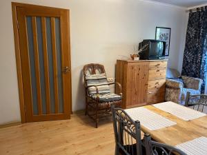 a living room with a table and a chair and a television at Three Bedroom Stepana Bandery Street in Rivne