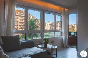 ein Wohnzimmer mit Couch und großem Fenster in der Unterkunft Apartamento en la playa de Brazomar wifi y garaje in Brazomar