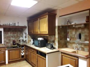 a large kitchen with wooden cabinets and a sink at Maison conviviale avec jardin à Vauban, 4 chambres in Vauban +11 photos