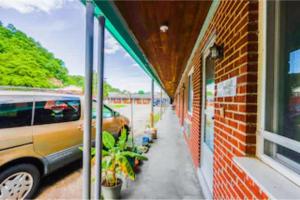 a building with a car parked next to a brick building at Travelers Inn by OYO Beaver, Hwy 19 in Glen Morgan