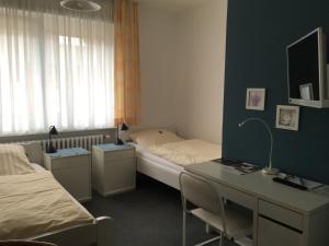 ein Zimmer mit einem Bett und einem Schreibtisch und einem Bett und einem Schreibtisch in der Unterkunft Hotel Wolbeck in Münster