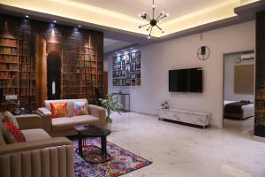 a large living room with couches and a tv at Veetil 3BHK AC, Kukatpally, Hyderabad in Hyderabad