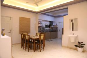 a dining room with a table and chairs and a sink at Veetil 3BHK AC, Kukatpally, Hyderabad in Hyderabad