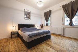 a bedroom with a large bed and two windows at Vintage Apartment 2 Black am Kurpark von Bad Ems in Bad Ems