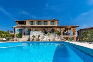 Villa Lathyrus San Lorenzo في Sveti Lovreč Pazenatički: منزل به حوض سباحة أمام المنزل