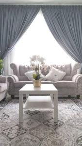 a living room with a couch and a table at Meraki Homestay Ladang Tanjung in Kuala Terengganu