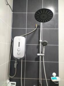 a shower in a bathroom with a shower head at Meraki Homestay Ladang Tanjung in Kuala Terengganu