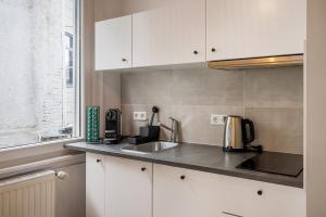 a kitchen with white cabinets and a sink at Vintage Apartment 1 am Kurpark von Bad Ems in Bad Ems