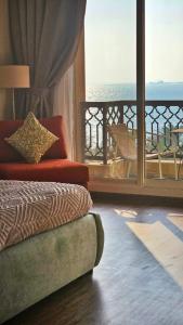 a room with a bed and a balcony with a view at Luxury Yakout 1BR Apartment in Ras al Khaimah
