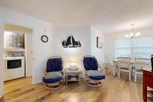 a kitchen and dining room with blue chairs and a table at Pelican Bay 46 in Isle of Palms