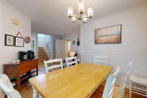 a dining room with a wooden table and white chairs at Pelican Bay 46 in Isle of Palms +23 photos