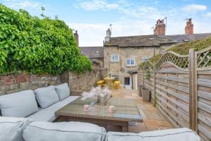 un soggiorno con divano e tavolo su un patio di Castle Yard Cottage a Knaresborough