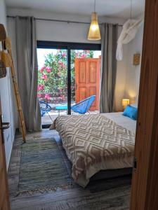 ラハレスにあるCasa Cocoon, Sun&Freedom, 8 mn from beaches, internet fiberのベッドルーム1室(ベッド1台付)、パティオへのドアが備わります。