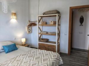 a bedroom with a bed and a book shelf at Casa Cocoon, Sun&Freedom, 8 mn from beaches, internet fiber in Lajares