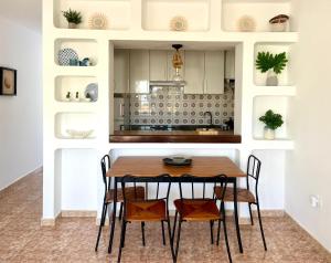 een keuken met een houten tafel en stoelen bij Encanto del mar, shared pool in Puerto del Carmen
