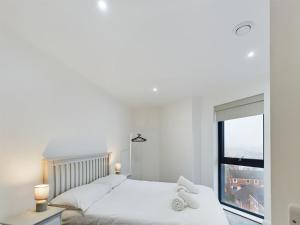 ein weißes Schlafzimmer mit einem Bett und einem Fenster in der Unterkunft Modern 2 bedroom Apartment in Belfast in Belfast