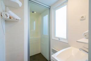a bathroom with a shower and a sink and a mirror at Camping Paradis 4 étoiles A La Corniche La Rochelle Angoulins in Angoulins-sur-Mer