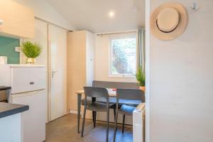 a kitchen and dining room with a table and chairs at Camping Paradis 4 étoiles A La Corniche La Rochelle Angoulins in Angoulins-sur-Mer
