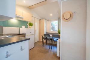 a kitchen with a table and chairs in a room at Camping Paradis 4 étoiles A La Corniche La Rochelle Angoulins in Angoulins-sur-Mer