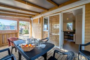 a table with a basket of fruit on a porch at Camping Paradis 4 étoiles A La Corniche La Rochelle Angoulins in Angoulins-sur-Mer