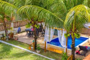 a resort with a swimming pool and palm trees at Pousada De Bona Studio's in Pôrto de Pedras