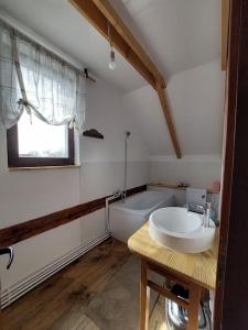 a bathroom with a sink and a bath tub at RéBa Old Barn in Estelnic