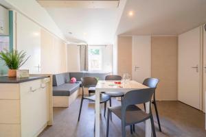 a kitchen and dining room with a table and chairs at Camping Paradis 4 étoiles A La Corniche La Rochelle Angoulins in Angoulins-sur-Mer