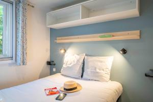 a hat sitting on top of a bed in a room at Camping Paradis 4 étoiles A La Corniche La Rochelle Angoulins in Angoulins-sur-Mer