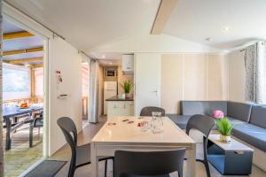 a living room and dining room with a table and chairs at Camping Paradis 4 étoiles A La Corniche La Rochelle Angoulins in Angoulins-sur-Mer