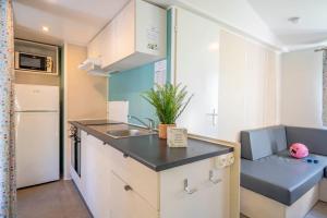 a small kitchen with a sink and a refrigerator at Camping Paradis 4 étoiles A La Corniche La Rochelle Angoulins in Angoulins-sur-Mer