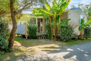 a house with a tent in front of it at Camping Paradis 4 étoiles A La Corniche La Rochelle Angoulins in Angoulins-sur-Mer