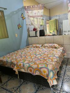 Un dormitorio con una cama con un edredón colorido. en RECANTO DO SABIÁ, en Carolina 83 fotos más