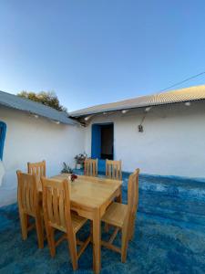 a wooden table and chairs in front of a house at The Endless Enigma in Tazroutane