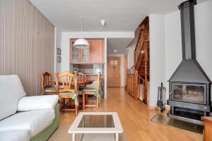 a living room with a couch and a fireplace at Argualas - Triplex con piscina - By CARDI Suites in Panticosa