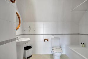 a white bathroom with a toilet and a sink at Argualas - Triplex con piscina - By CARDI Suites in Panticosa +73 photos