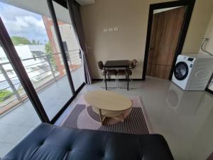 a view of a living room with a table and a microwave at Rawai beach condominium 拉薇海滩酒店公寓 in Nai Harn Beach