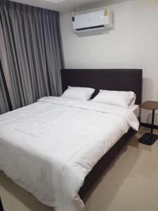 a bed with white sheets and pillows in a bedroom at Rawai beach condominium 拉薇海滩酒店公寓 in Nai Harn Beach +17 photos
