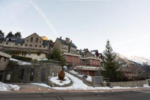 a town with snow on the ground and buildings at Argualas - Triplex con piscina - By CARDI Suites in Panticosa