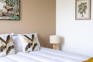 a bedroom with a bed with white sheets and a lamp at Le Bohème Classé 3 étoiles in La Londe-les-Maures +4 photos