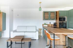 a kitchen with green cabinets and a table with chairs at Le Bohème Classé 3 étoiles in La Londe-les-Maures