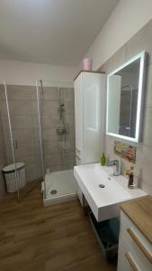a bathroom with a white sink and a shower at Családbarát lakás Szombathely szívében in Szombathely