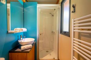 a bathroom with a sink and a shower at Camping Paradis 4 étoiles A La Corniche La Rochelle Angoulins in Angoulins-sur-Mer