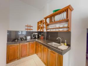 a kitchen with wooden cabinets and a sink at Oshi villa in Unawatuna