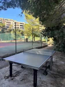 a ping pong table in front of a tennis court at Appartement lumineux Vue Mer, Piscine et tennis in Nice