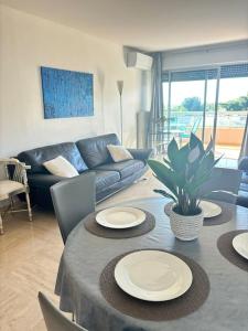 a living room with a table with plates on it at Appartement lumineux Vue Mer, Piscine et tennis in Nice