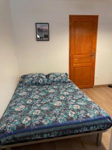 a bedroom with a bed and a wooden door at Logis sympa proche des thermes in Saint-Pierre-dʼAllevard