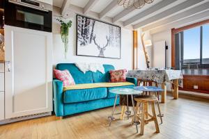 a living room with a blue couch and a table at Les Alysses - Maison pour 5 avec garage in Font-Romeu