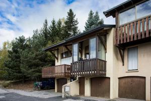 a house with wooden balconies on the side of it at Les Alysses - Maison pour 5 avec garage in Font-Romeu